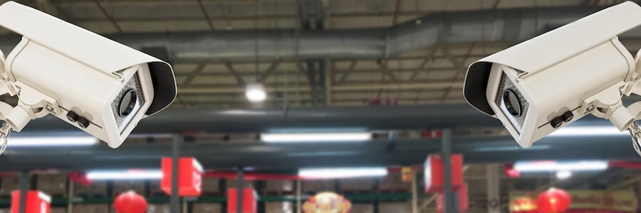 CCTV surveillance cameras pointed towards each other in a warehouse