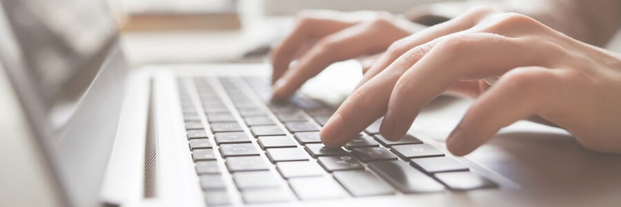 A person at a computer doing remote monitoring of a business surveillance system