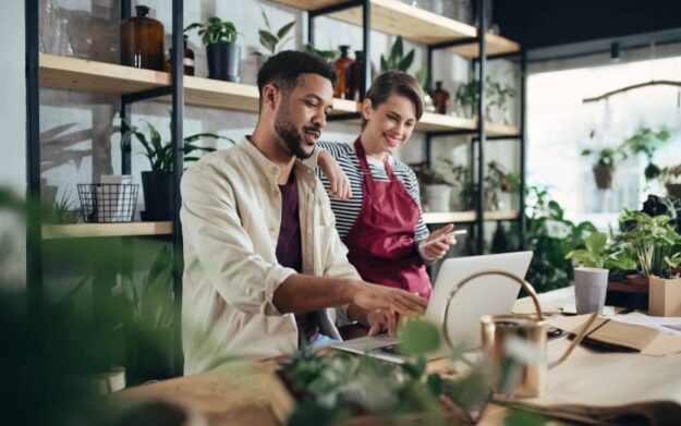 small business owners looking at a computer inside a plant shop