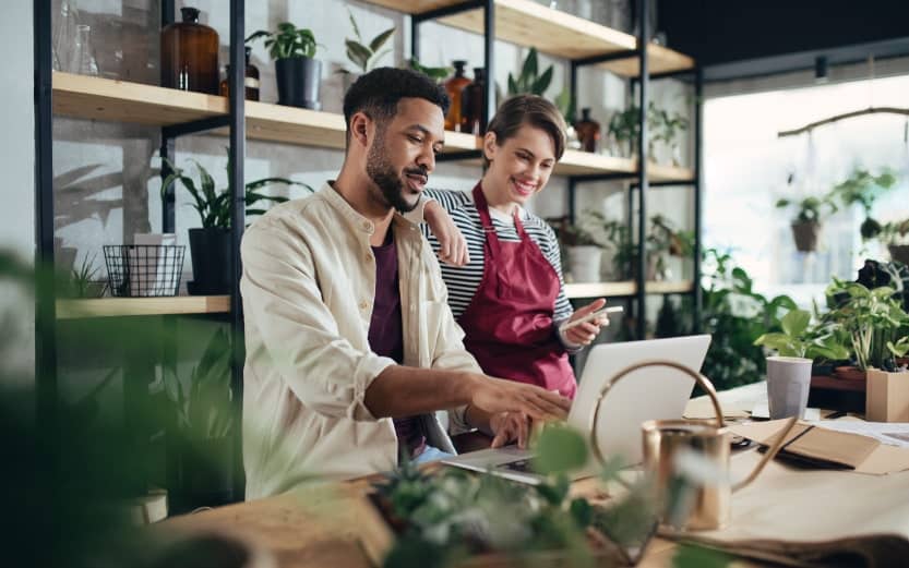 small business owners looking at a computer inside a plant shop