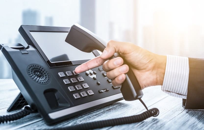man picking up a voip business phone in austin