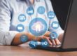 Overlay of cloud computing services over the body of someone typing on a laptop.