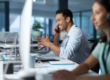 Shot of a young man answering the phone while working in a modern call center.