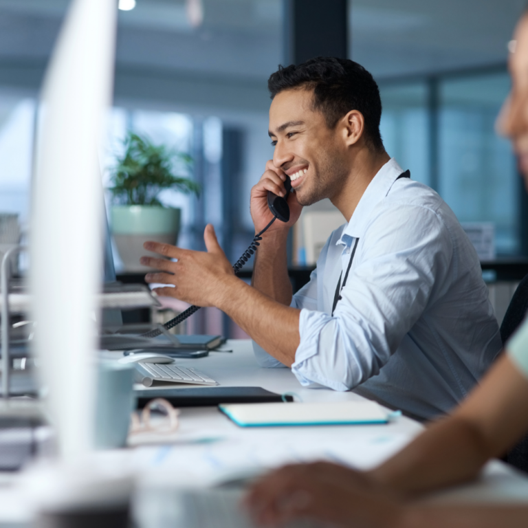 Shot of a young man answering the phone while working in a modern call center.