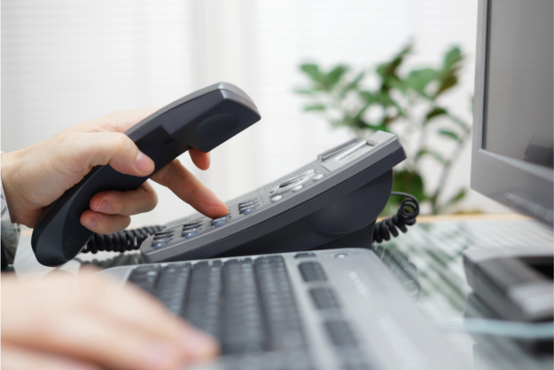 Businessman dialing a phone number in the office on an office phone.