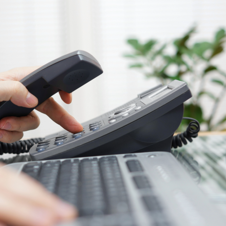 Businessman dialing a phone number in the office on an office phone.